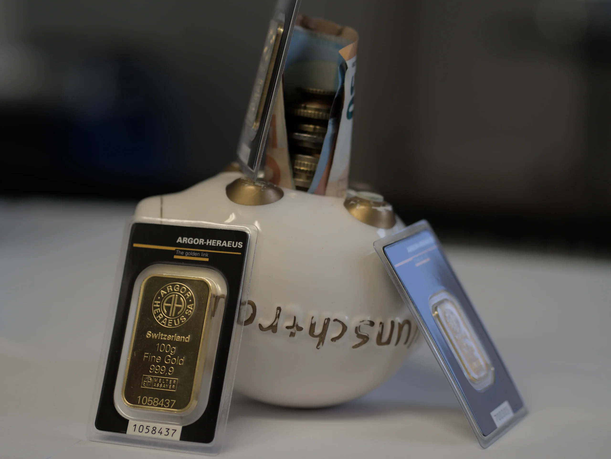 Goldbarren in Blisterverpackung neben Laborschale, Investmentgold von m&k